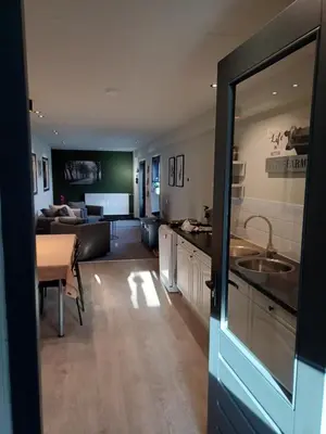 a kitchen and living room with a couch and a table at Boerderij Appartement Jachtlust in Voorhout