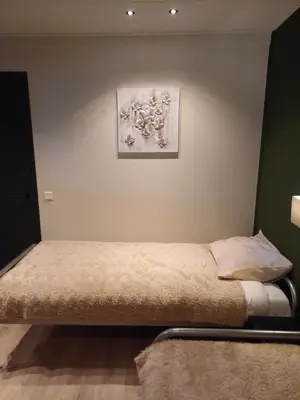 a bed in a room with a painting on the wall at Boerderij Appartement Jachtlust in Voorhout