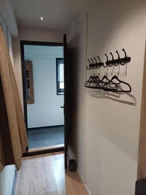 a room with a wall with hangers on the wall at Boerderij Appartement Jachtlust in Voorhout