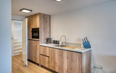 a kitchen with wooden cabinets and a sink at Stunning Home In Bergen Aan Zee in Bergen aan Zee