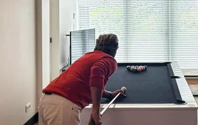 a man is playing pool on a table at Stunning Home In Bergen Aan Zee in Bergen aan Zee