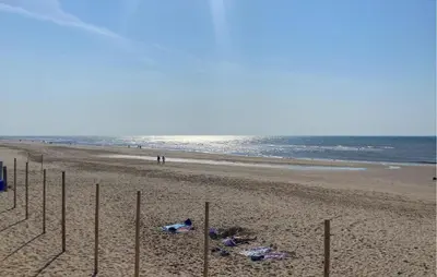 a beach with people laying on the sand at Stunning Home In Bergen Aan Zee in Bergen aan Zee