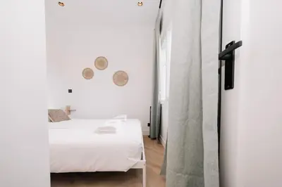 a white bedroom with a bed and a mirror at Bella Beach House in Zandvoort