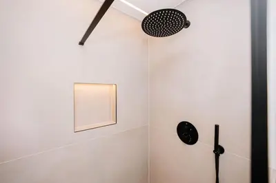 a bathroom with a shower with a fan and a mirror at Bella Beach House in Zandvoort
