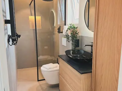 a bathroom with a black sink and a toilet at Bella Beach House in Zandvoort