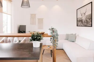 a living room with a white couch and a table at Bella Beach House in Zandvoort