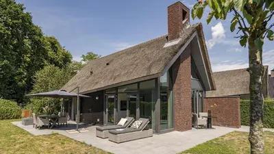 a house with a roof that has a patio at Dutchen Villapark Mooi Schoorl in Schoorl