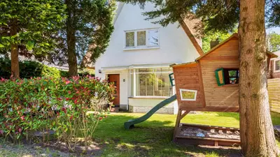 a tree house with a slide in front of a house at Emma's Atelier in Bergen