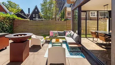 a patio with a couch and a table and a grill at Emma's Atelier in Bergen