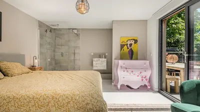 a bedroom with a pink bed and a shower at Emma's Atelier in Bergen