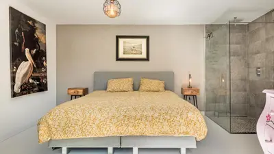 a bedroom with a bed and a glass shower at Emma's Atelier in Bergen