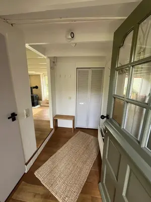 a hallway with a door and a rug at Rekerlanden 6 in Warmenhuizen
