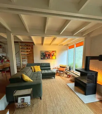 a living room with a couch and a stove at Rekerlanden 6 in Warmenhuizen