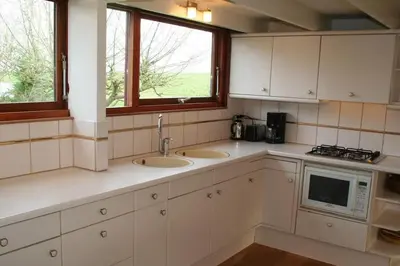a kitchen with two sinks and a microwave at Rekerlanden 6 in Warmenhuizen