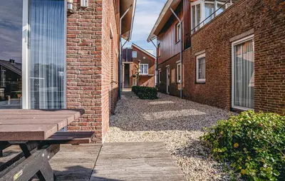 an empty alley with a bench next to a brick building at Westergeest Luxe in Uitgeest