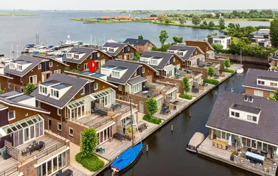 a group of houses on the water with a marina at Westergeest Luxe in Uitgeest