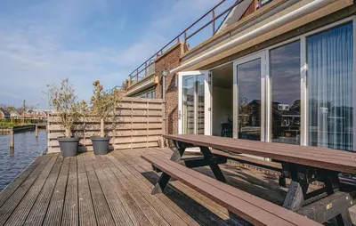 a wooden deck with a bench next to a building at Westergeest Luxe in Uitgeest