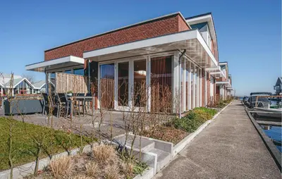 a brick building with a patio next to a marina at Saskerlei in Uitgeest