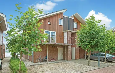 a brick house with a balcony and a car at Oostergeest 3 6P in Uitgeest