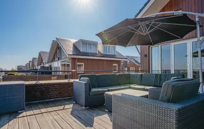 a patio with a couch and chairs and an umbrella at Oostergeest 3 6P in Uitgeest