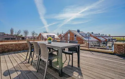 a table and chairs on top of a roof at Oostergeest 3 6P in Uitgeest