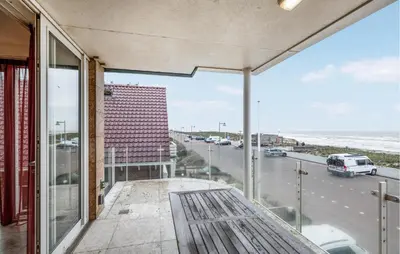 a balcony with a bench and a view of the ocean at Appartement Crab in Egmond aan Zee