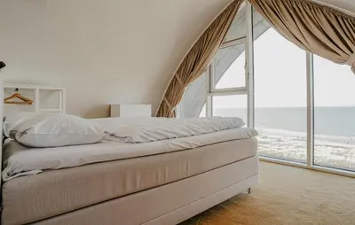 a bedroom with a bed with a view of the ocean at Shrimp in Egmond aan Zee