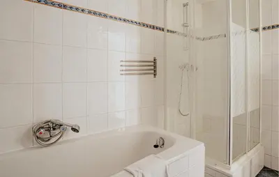 a white bathroom with a tub and a shower at Westergeest 3 6P in Uitgeest