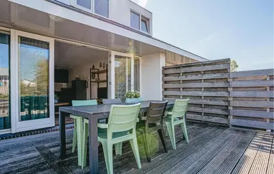 a wooden table and chairs on a deck at Busch & Dam in Uitgeest