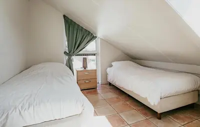 a bedroom with two beds and a window at Busch & Dam in Uitgeest