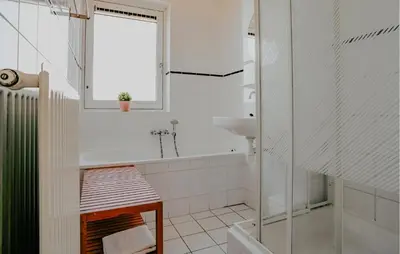 a white bathroom with a tub and a sink at Busch & Dam in Uitgeest