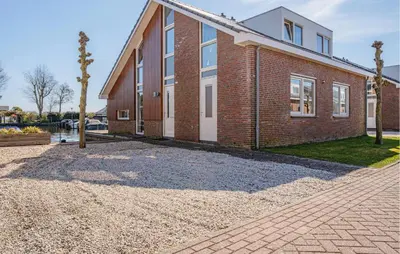 a brick house with a gravel driveway in front of it at Busch & Dam in Uitgeest