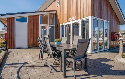 a table and chairs on a patio with a building at Kraaijennest in Uitgeest