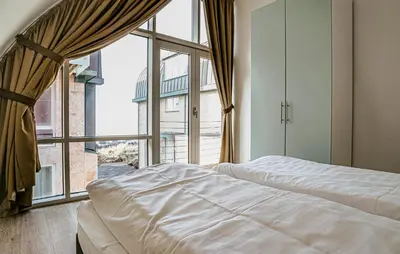 a bedroom with a bed and a large window at Sea Bass in Egmond aan Zee