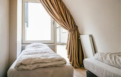 a bed in a room with a window at Sea Bass in Egmond aan Zee