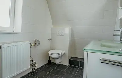 a white bathroom with a toilet and a sink at Sea Bass in Egmond aan Zee