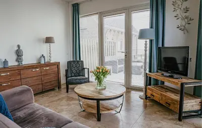 a living room with a couch and a tv and a table at Flat Fish in Egmond aan Zee
