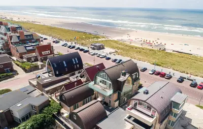 an aerial view of a beach with buildings and cars at Flat Fish in Egmond aan Zee