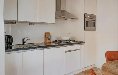 a white kitchen with a sink and a stove at Flat Fish in Egmond aan Zee