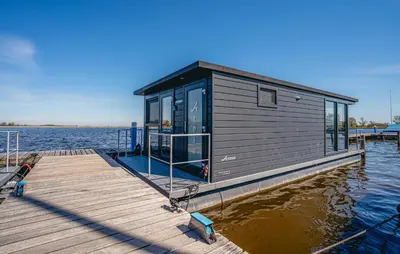 a tiny house on a dock on the water at Havenlodge Plus in Uitgeest