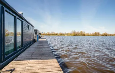 a house on a dock on a body of water at Havenlodge Plus in Uitgeest