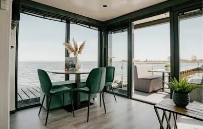 a dining room with a view of the water at Havenlodge Plus in Uitgeest