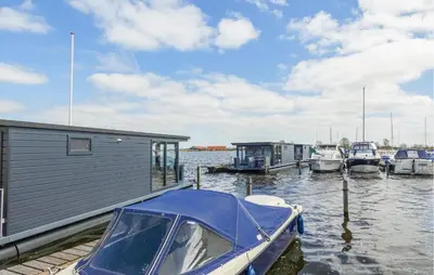 a boat is docked at a marina with other boats at Havenlodge Plus in Uitgeest
