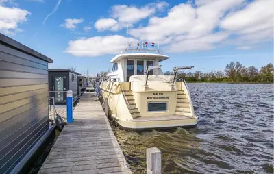 a boat is docked at a dock on the water at Havenlodge Plus in Uitgeest