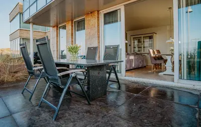 a patio with a table with two laptops on it at Lobster in Egmond aan Zee