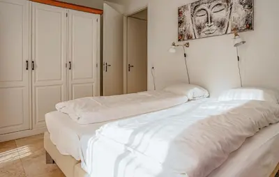 two white beds in a room with white cabinets at Lobster in Egmond aan Zee