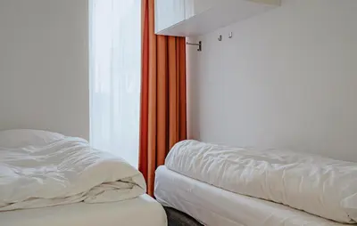 a bed sitting next to a window in a room at Lobster in Egmond aan Zee