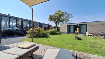 a backyard of a house with a bench and grass at Studio in Amsterdam Area Horizon Hideaway in Broek in Waterland