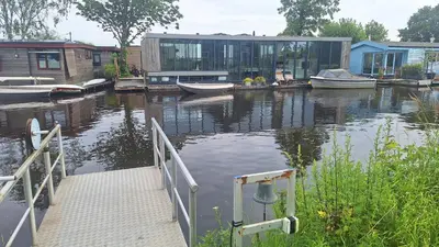 a house with a dock and boats in the water at Studio in Amsterdam Area Horizon Hideaway in Broek in Waterland