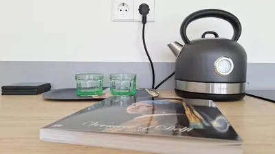 a magazine on a table with a tea kettle and glasses at Studio in Amsterdam Area Horizon Hideaway in Broek in Waterland